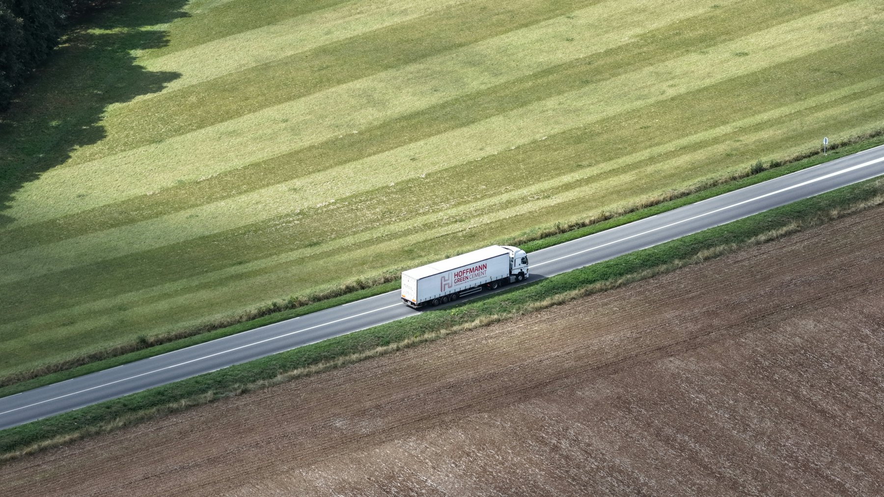 Freight truck on a road between fields